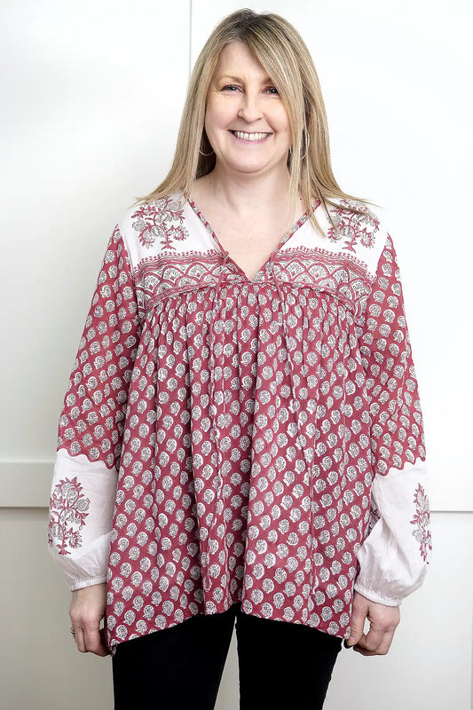 Woman wearing a red and white patterned Seaberry Gypsy Top against a white background - front view