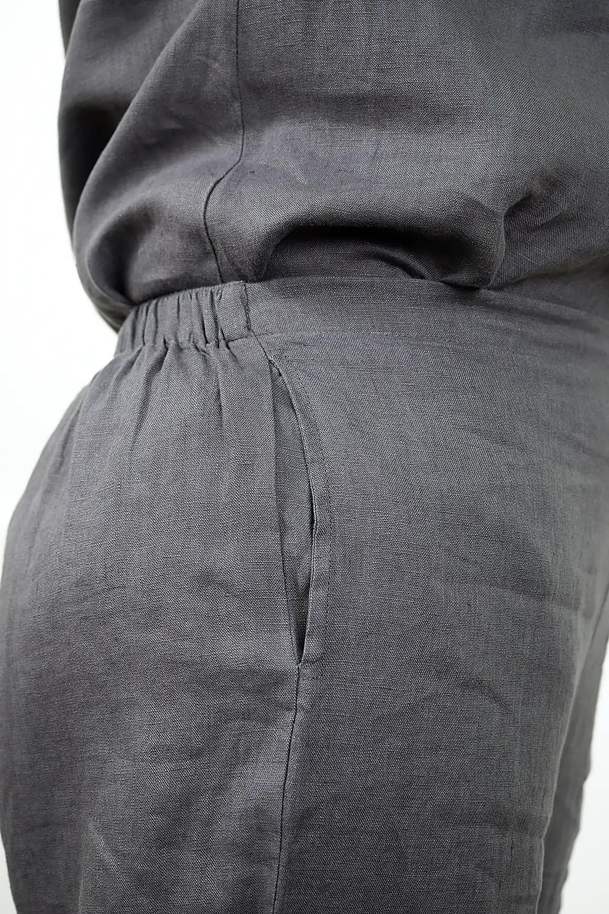 Close-up of See Saw Linen 7/8 Flat Front Pant and cowl neck top in Charcoal showing waist and pocket details with a white background
