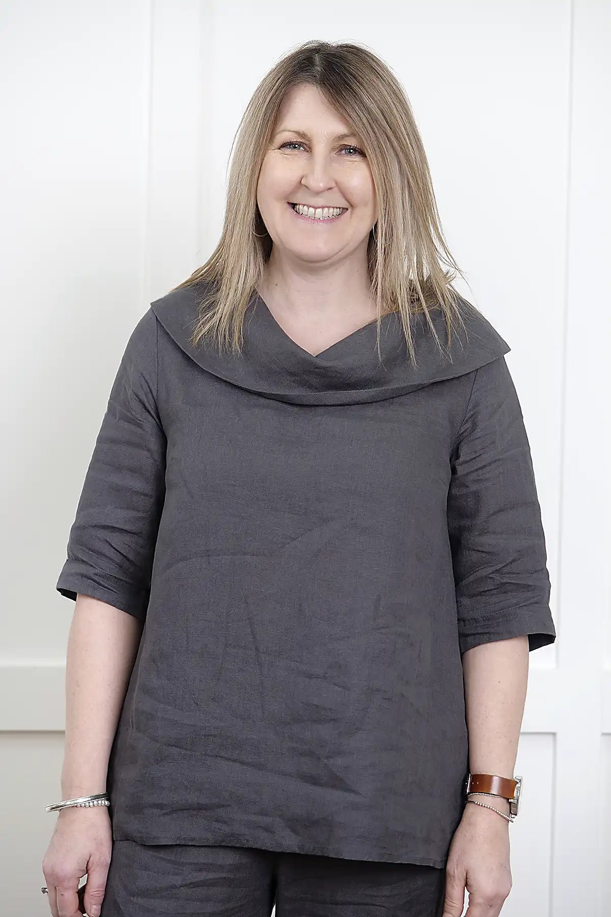 Woman wearing a See Saw Linen Cowl Neck Top in Charcoal and pants against a white background