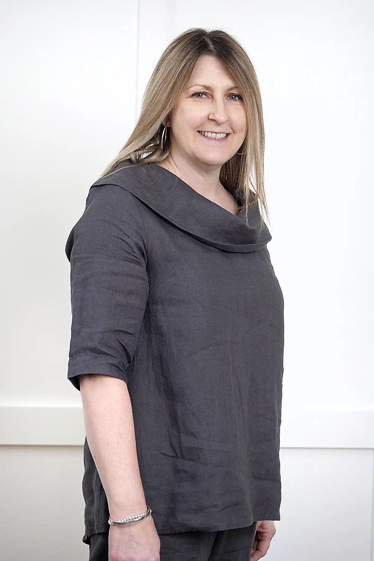 Woman wearing a See Saw Linen Cowl Neck Top in Charcoal side on detail view against a white background