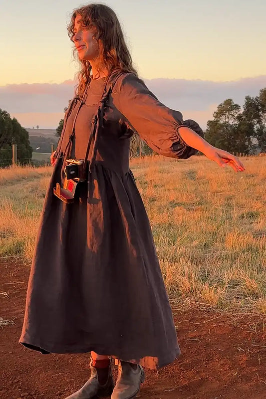 Sofia Linen Pinafore Dress – Dark Chocolate front 3/4 view on the farm