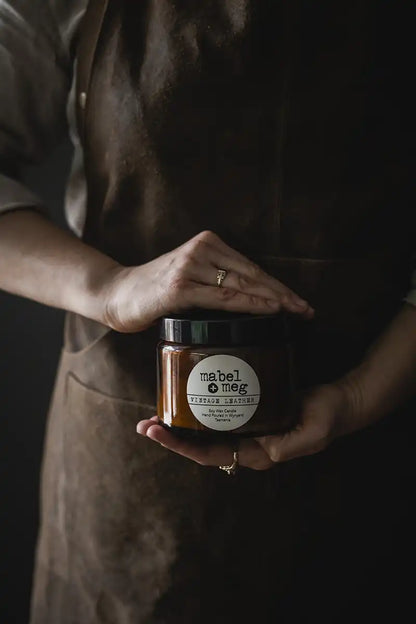 Mabel + Meg XL Soy Candle Vintage Leather in ladys hands with leather apron
