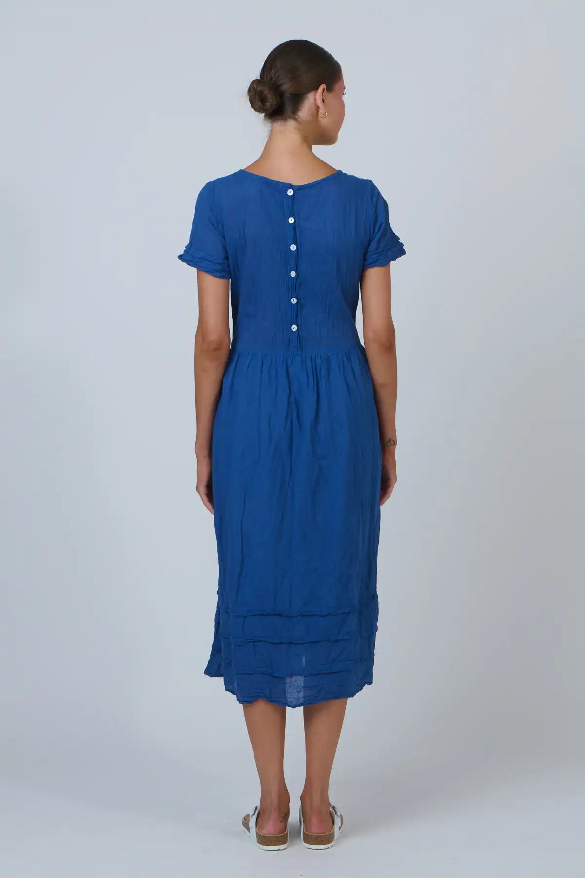 Woman wearing a blue dress with a white background