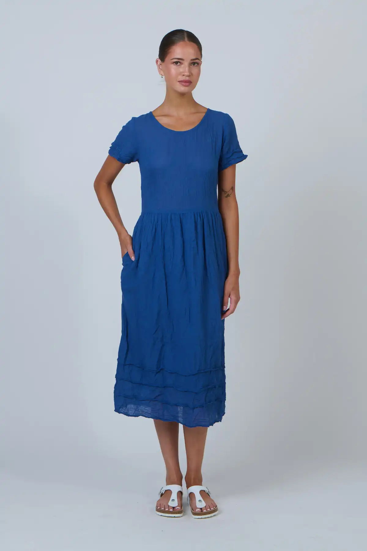 Woman wearing a blue dress against a white background