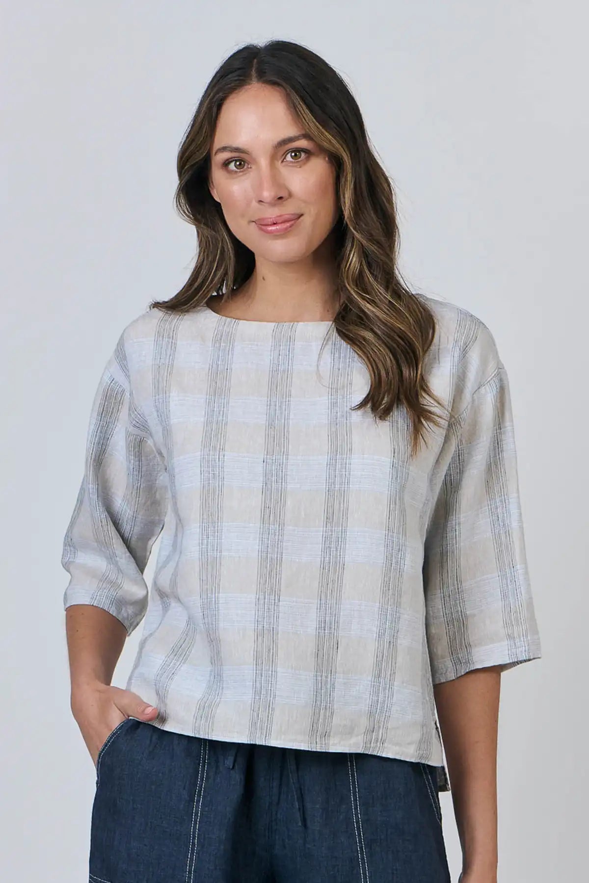 Woman wearing a Mesh Linen Breeze Top and dark pants against a plain background