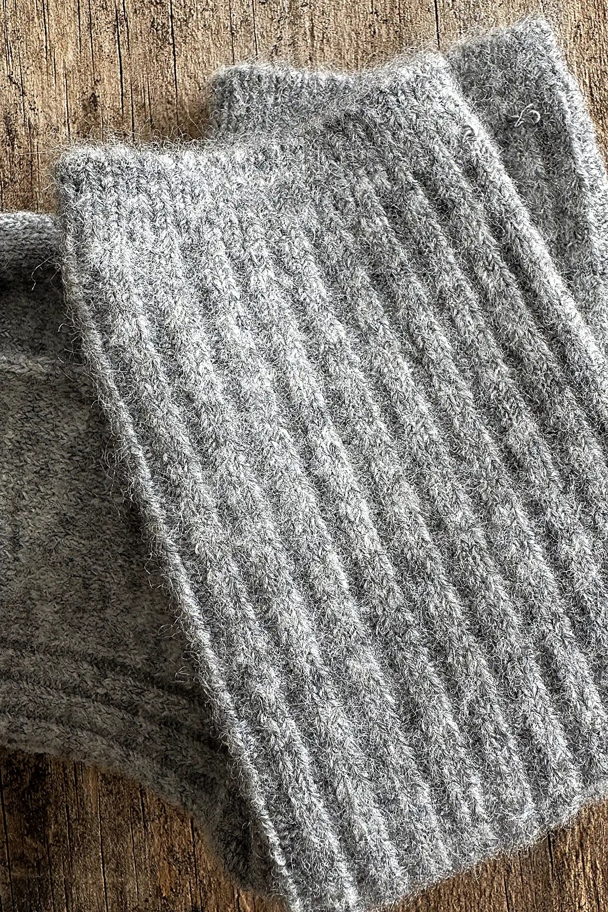 Gray ribbed knit socks on a wooden surface