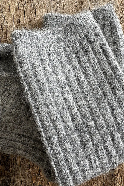 Gray ribbed knit socks on a wooden surface