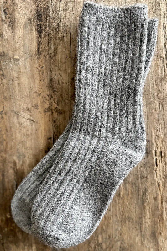 Gray wool blend sock on a wooden surface