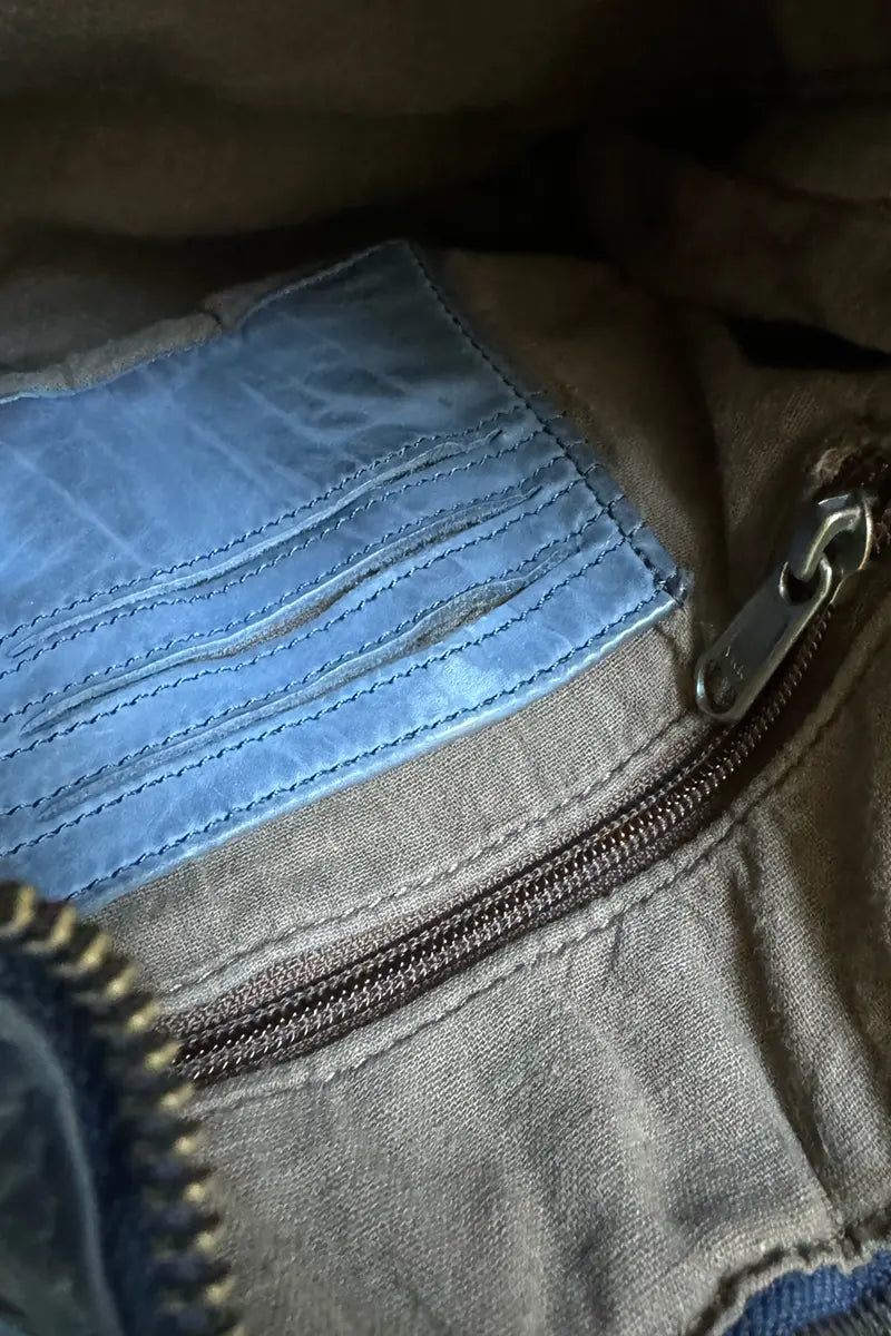 Showing detail of the card slots and zip pocket inside the Rugged Hide Jackie Cross Body Bag in Navy