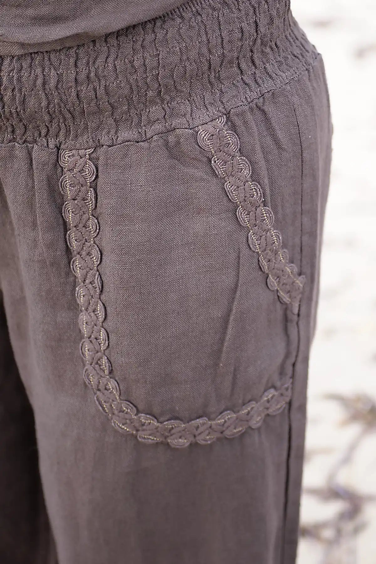 Close-up of chocolate pants with lace trim on a blurred natural background