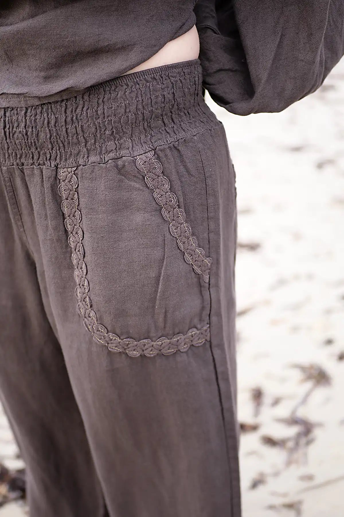 Chocolate Brown pants with lace detailing on a blurred natural background