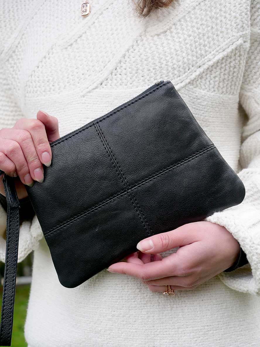 model holding the Rugged Hide Mia Leather Clutch in Black