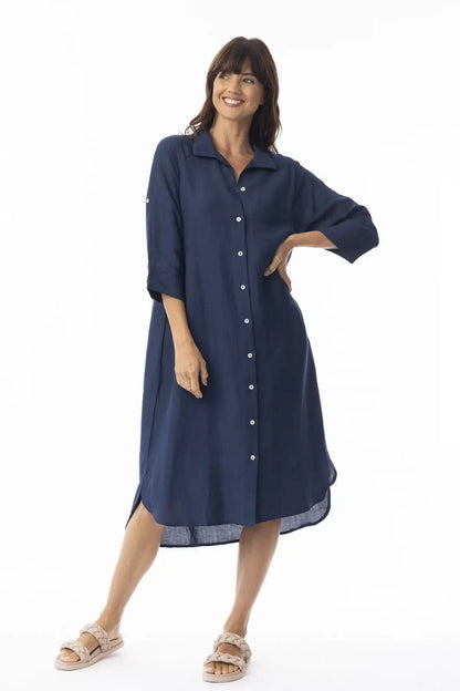 Woman wearing a Orientique Linen Solid Navy Shirt Dress with white buttons on a white background