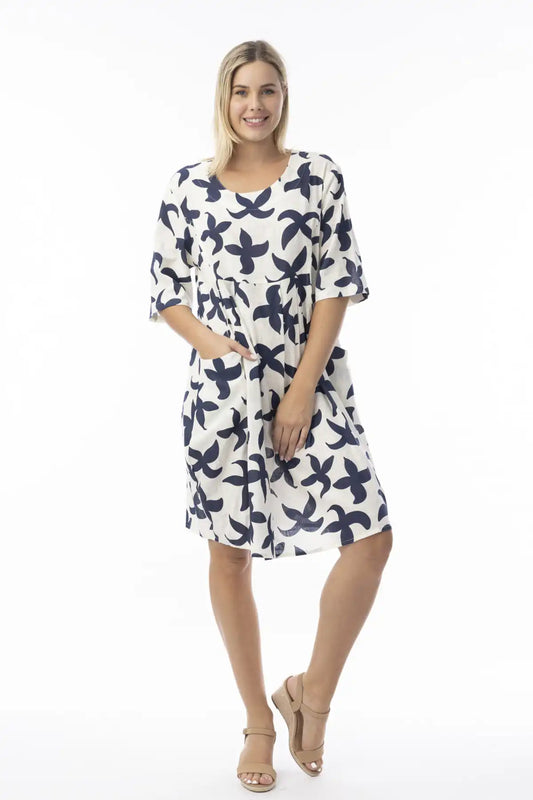 Woman wearing a white dress with blue floral pattern on a white background