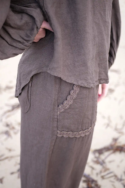 chocolate outfit with lace details and curved hemline on a blurred background