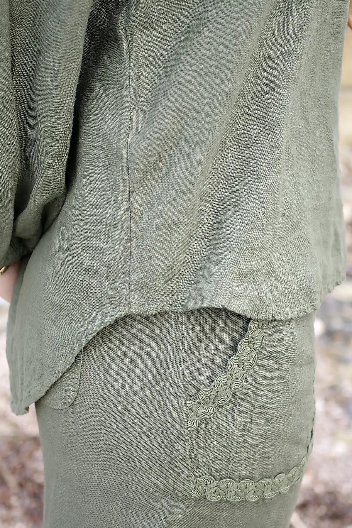 Green linen garment with lace trim in a natural setting