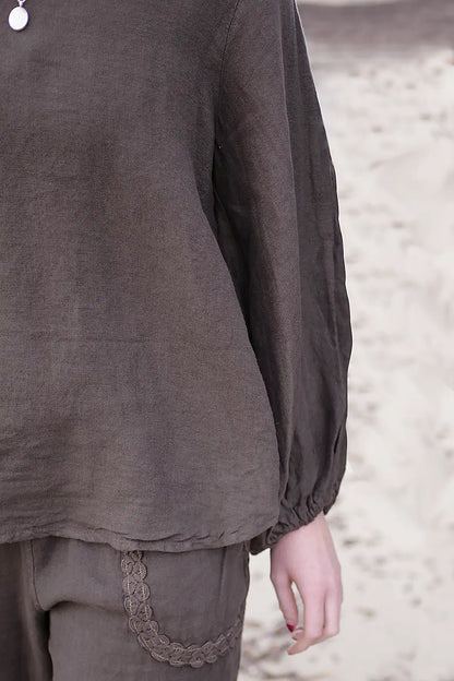 Brown long-sleeve top with lace trim on a neutral background