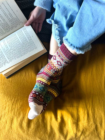 model on bed reading wearing Nordic Style Socks in Burgundy
