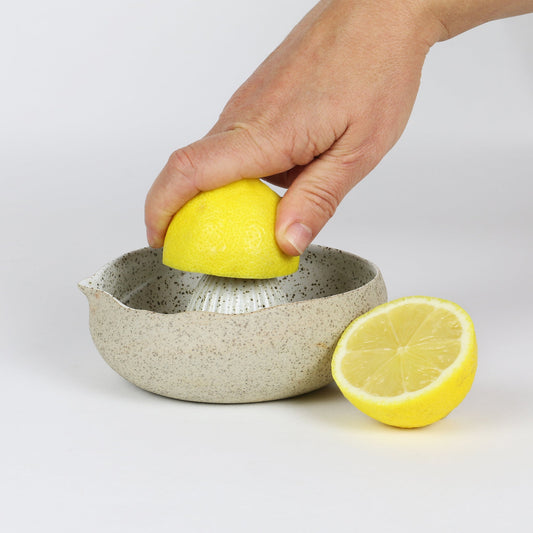 lemon being squeezed in garden table juicer