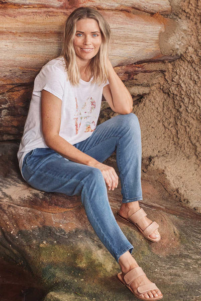 Ada Denim Pants model sitting on rocks