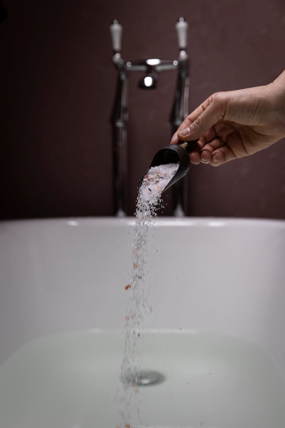 Pouring bath salt into bath